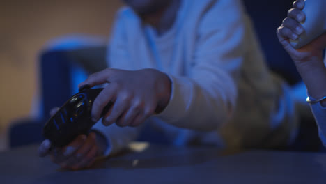 Close-Up-Of-Two-Young-Boys-At-Home-Playing-With-Computer-Games-Console-On-TV-Holding-Controllers-Late-At-Night-5